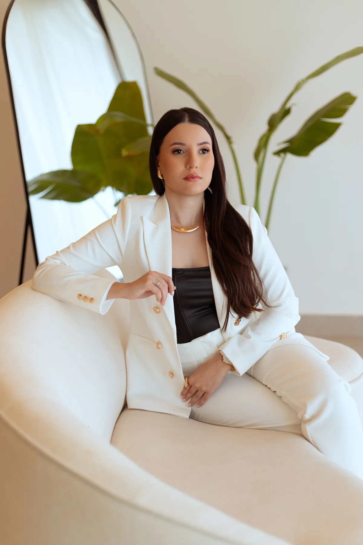 Melissa Fialho sentada em um sofá branco